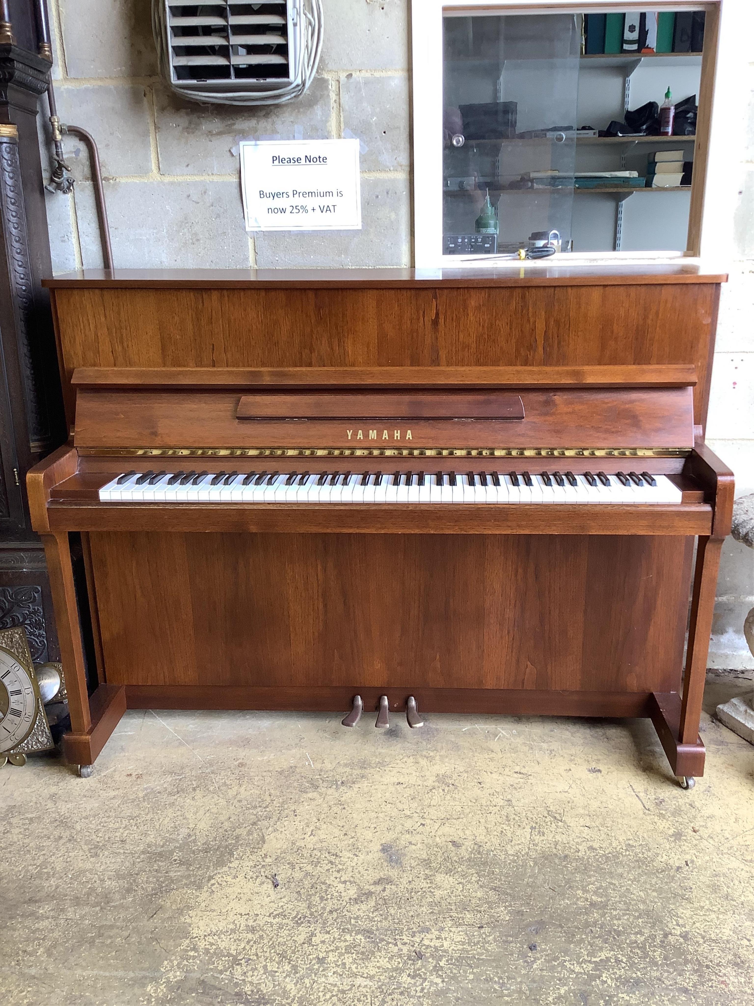 A Yamaha upright piano, model P116N, serial no.E252968, with its original sales booklet and an adjustable piano stool. Condition - good, in very good lightly used condition